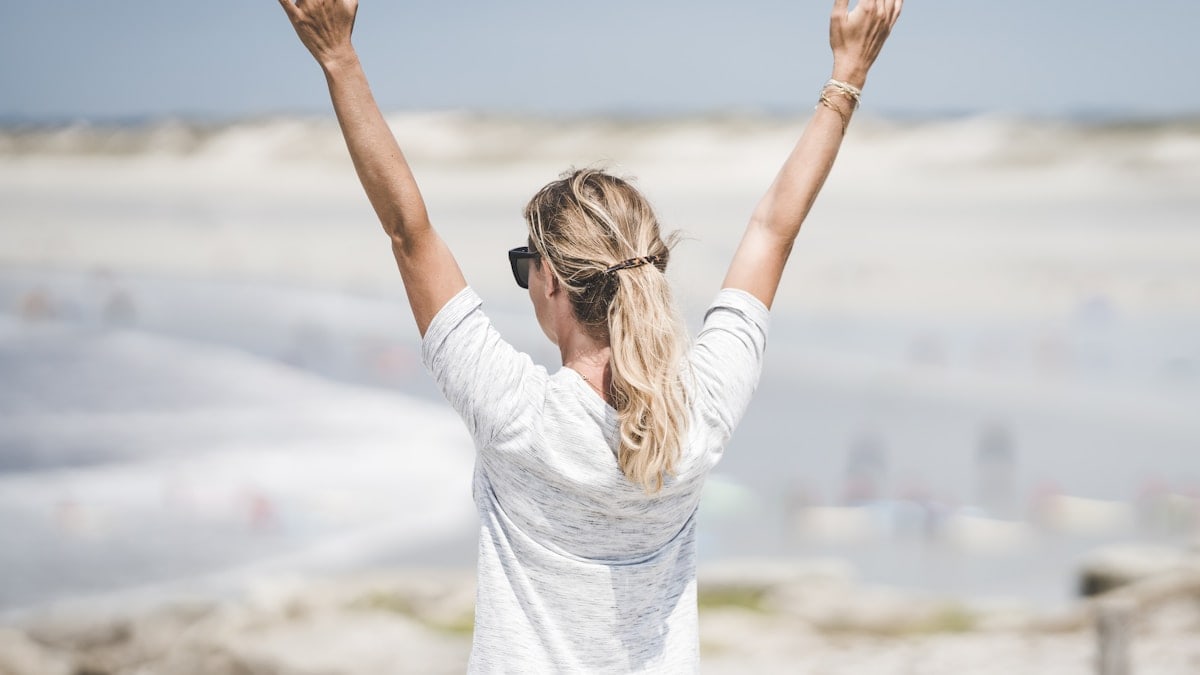 woman in white long sleeve shirt raising her hands
